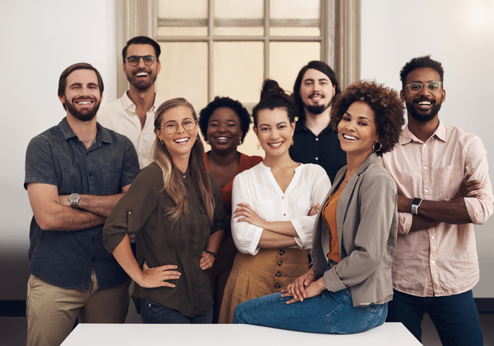 grupo diverso de colaboradores sorrindo e demonstrando confiança na empresa.