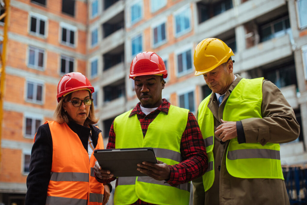 Profissionais usando um tablet para controlar o estoque e trabalhar na construção civil.